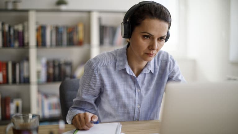 woman-with-earphones-looking-at-laptop
